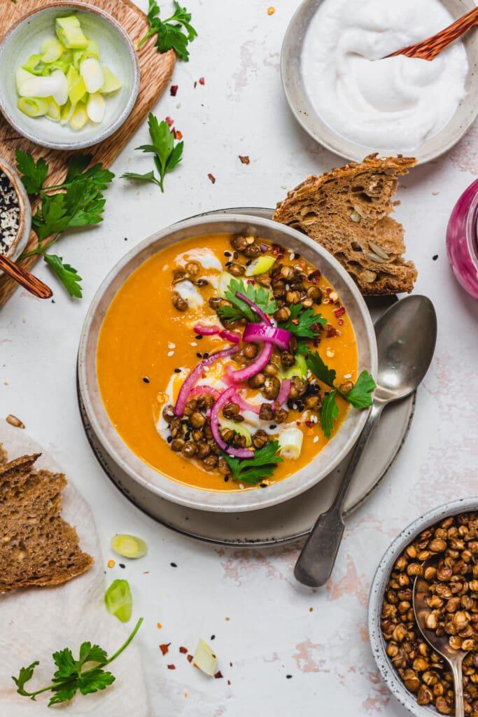 a lentil soup protein bowl being assembled with various toppings