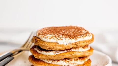 side shot of gluten-free tiramisu pancakes with a fork cutting into the stack