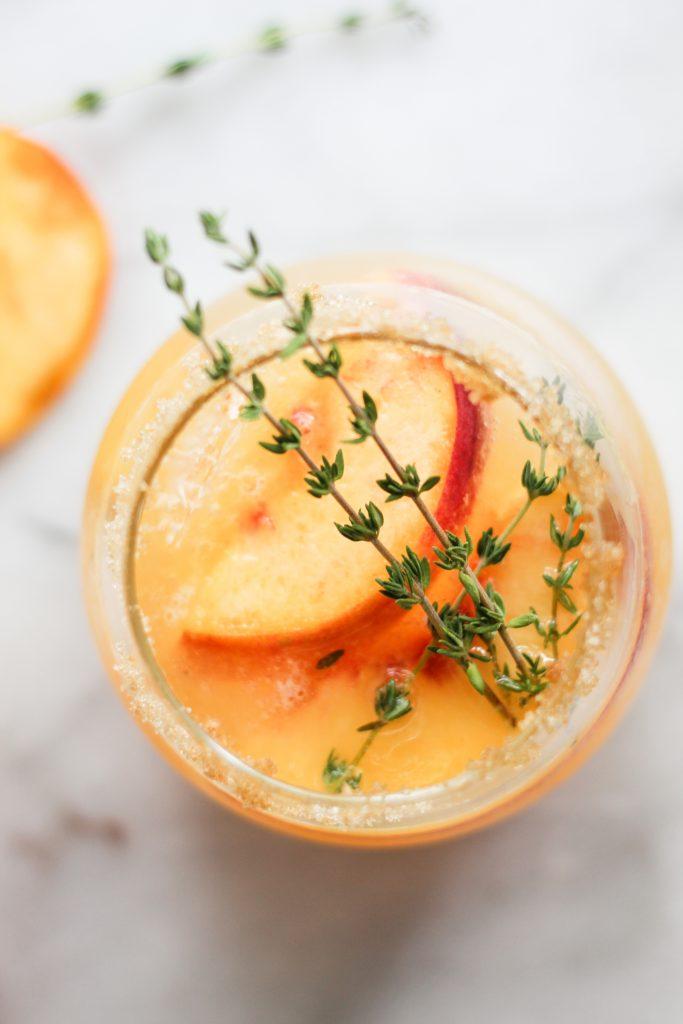 close-up of peach slices and fresh thyme sprigs