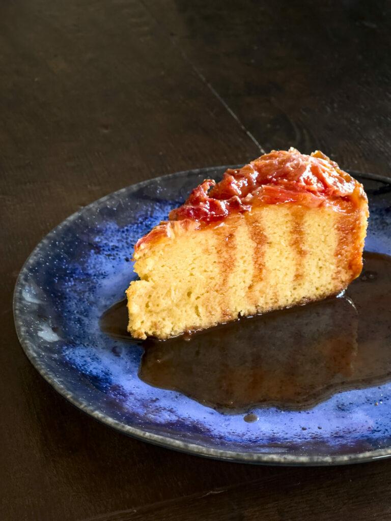 a person cutting a slice of blood orange olive oil cheesecake
