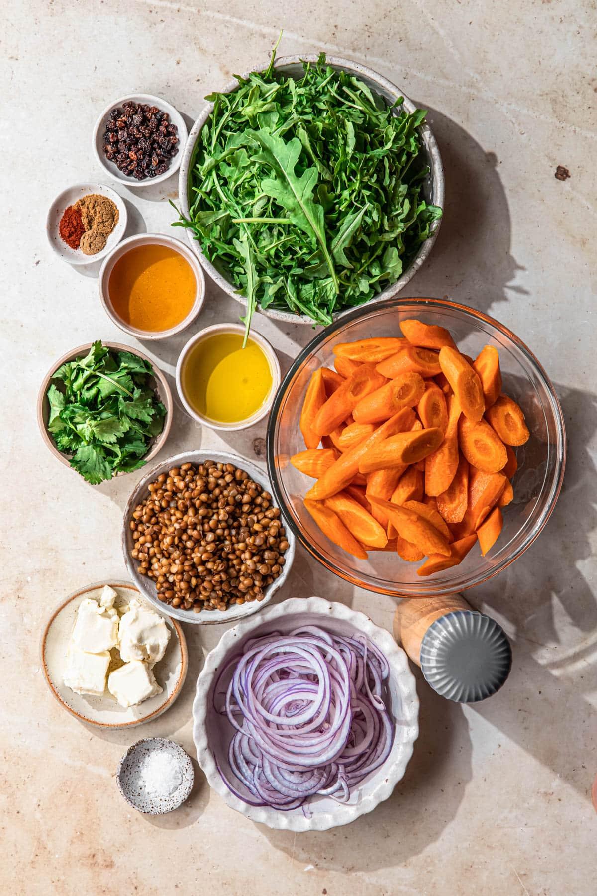 overhead shot of ingredients for lentil and carrot protein bowl laid out on a wooden surface
