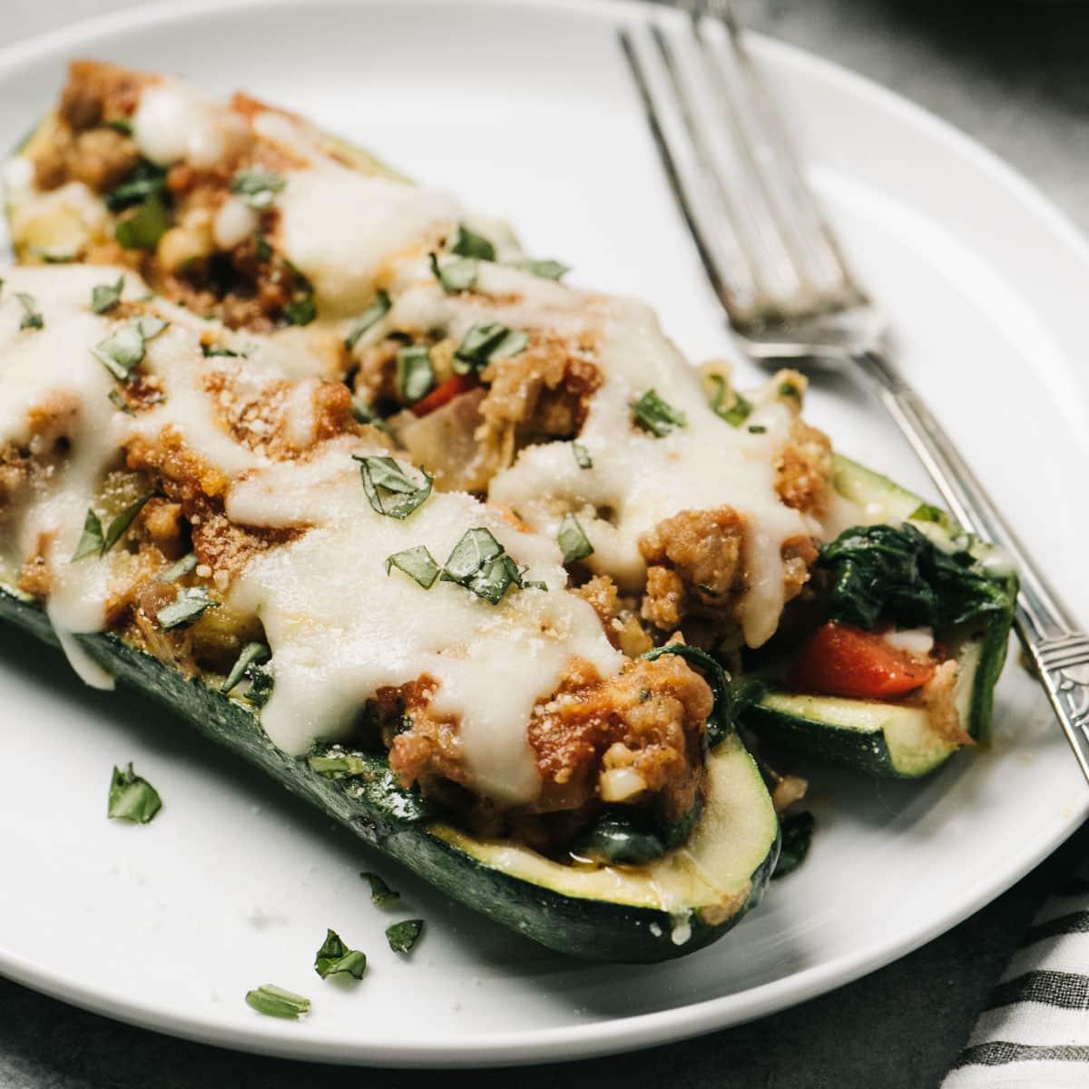 baked Skinny Italian Sausage Stuffed Zucchini with Spinach on a plate
