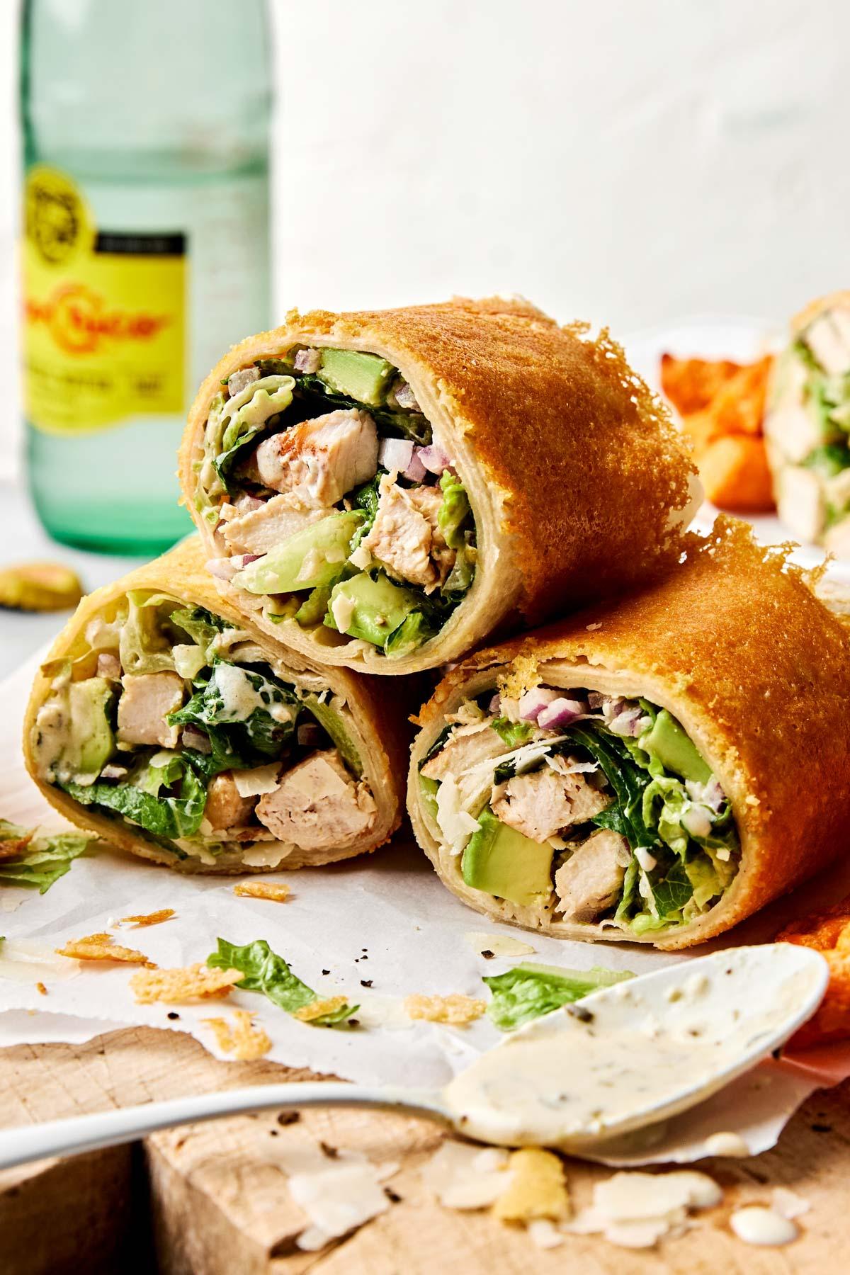 ingredients for mini chicken caesar salad wraps laid out on a wooden surface