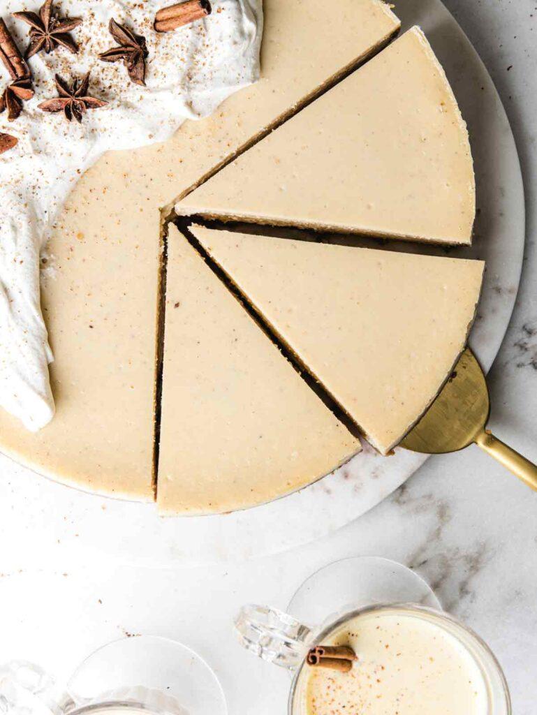 overhead shot of eggnog cheesecake being sliced with a knife