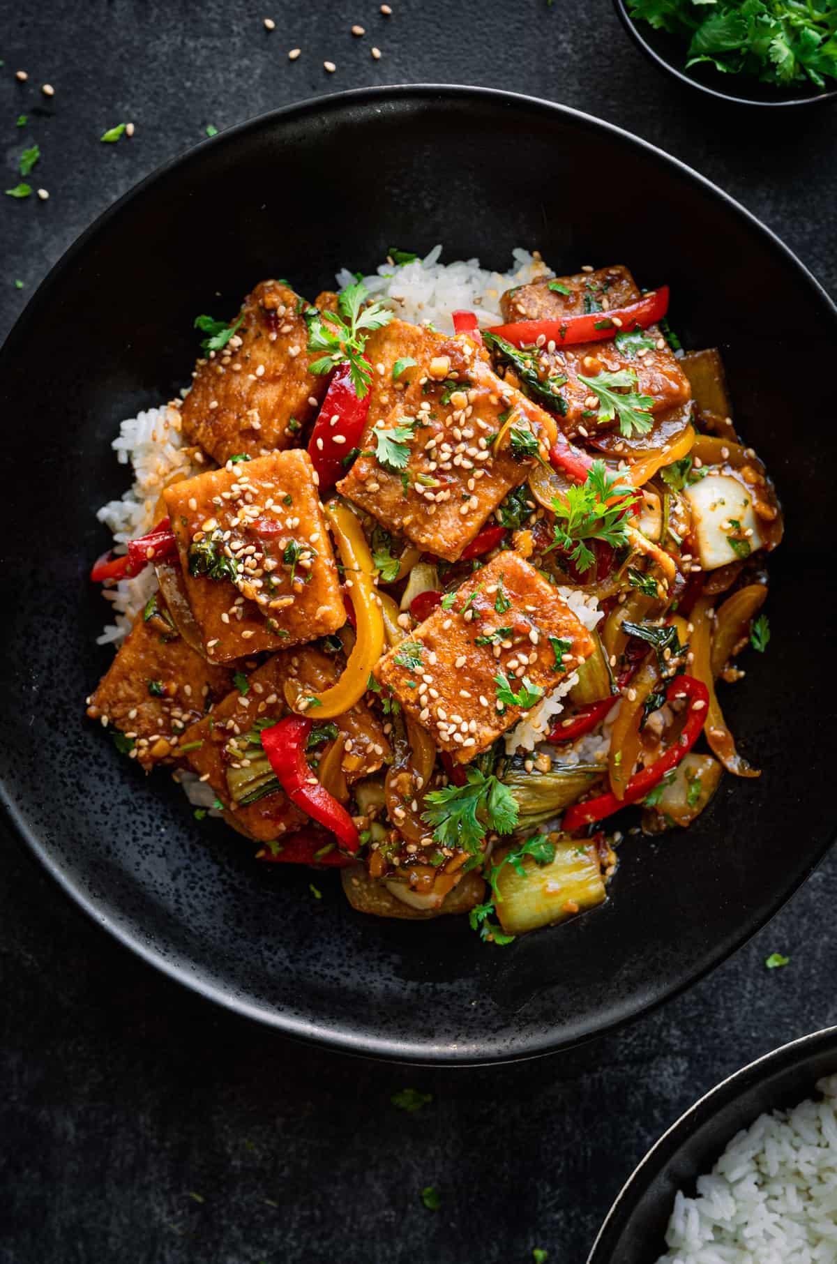 Close-up shot of a vibrant Colombian tofu stir-fry, showcasing the textures and colors of the ingredients