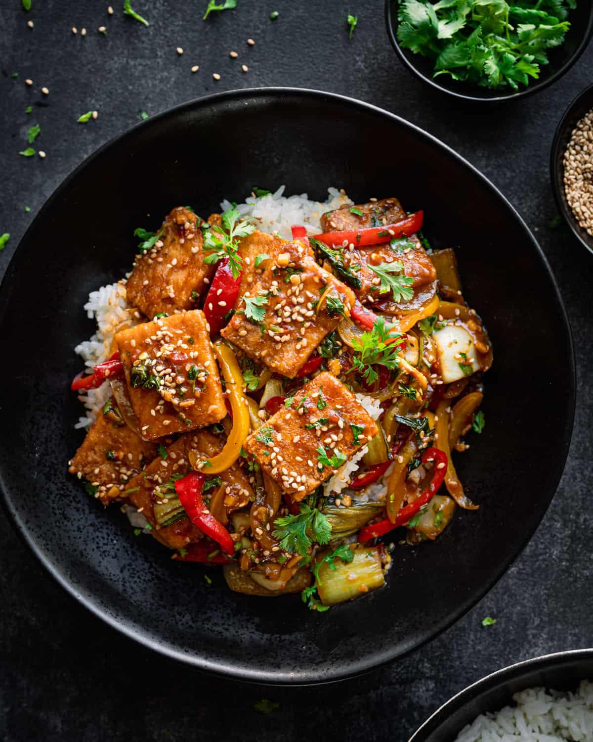 Close-up of a wok with tofu and vegetables being stir-fried