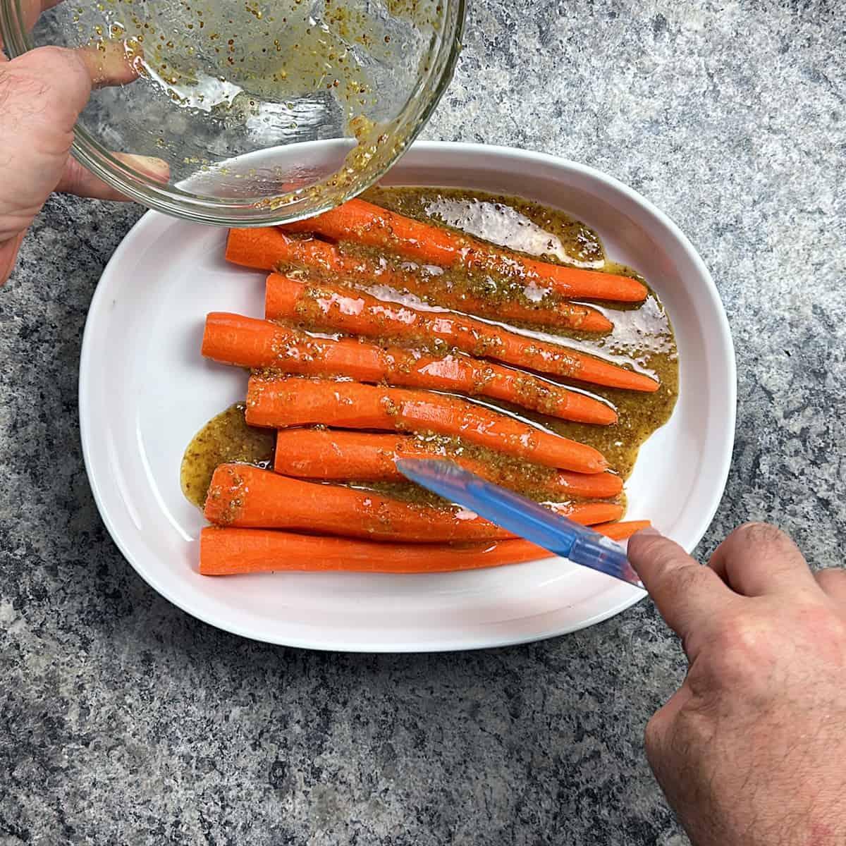 close up shot of honey mustard being drizzled over carrots