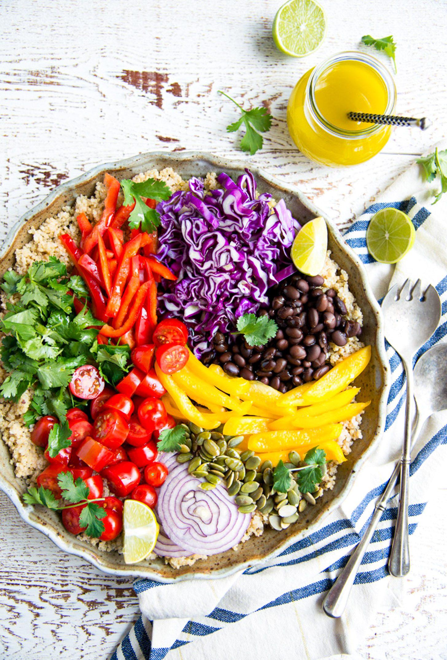 overhead shot of a beautifully arranged quinoa bowl with summer vegetables and a lime wedge
