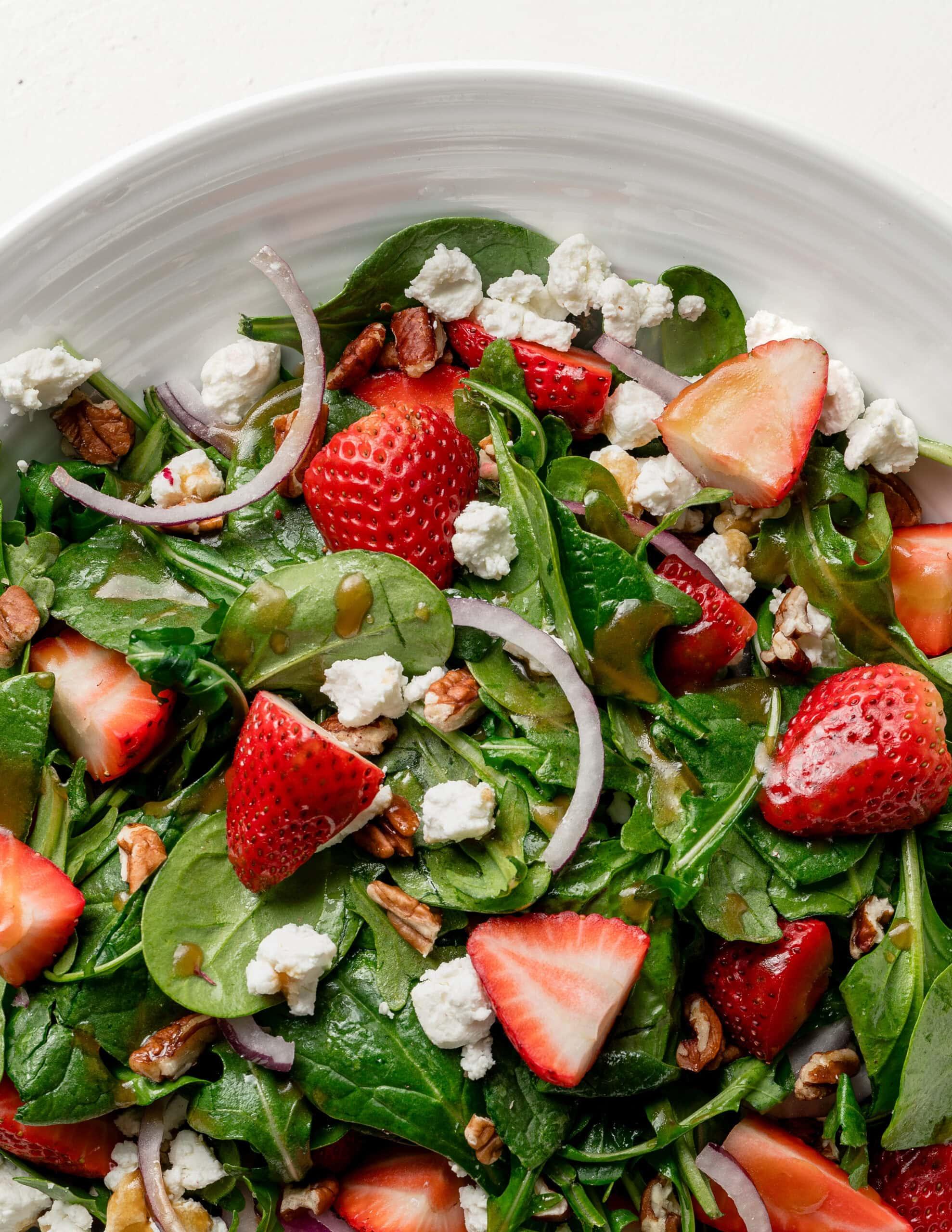 overhead shot of a vibrant strawberry spinach salad with arugula