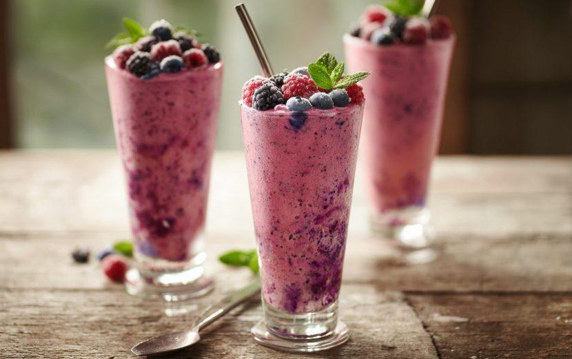 vibrant smoothie being poured into a glass, showcasing a mix of fruits and a sprinkle of seeds