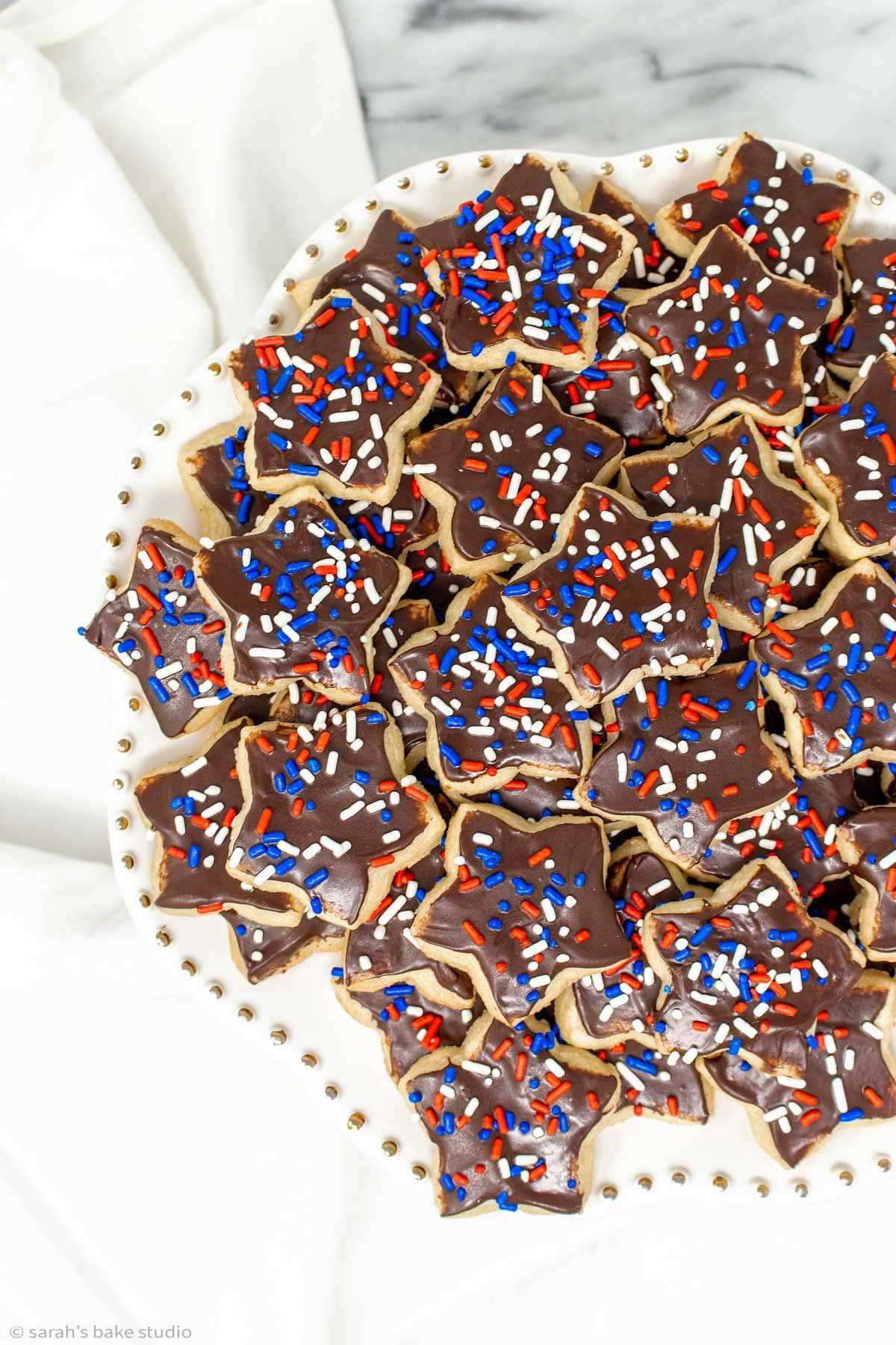 close up of someone decorating a patriotic star cookie with sprinkles