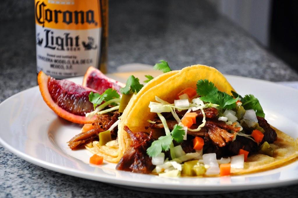 close-up shot of blood orange chili ground beef tacos topped with cilantro and a lime wedge