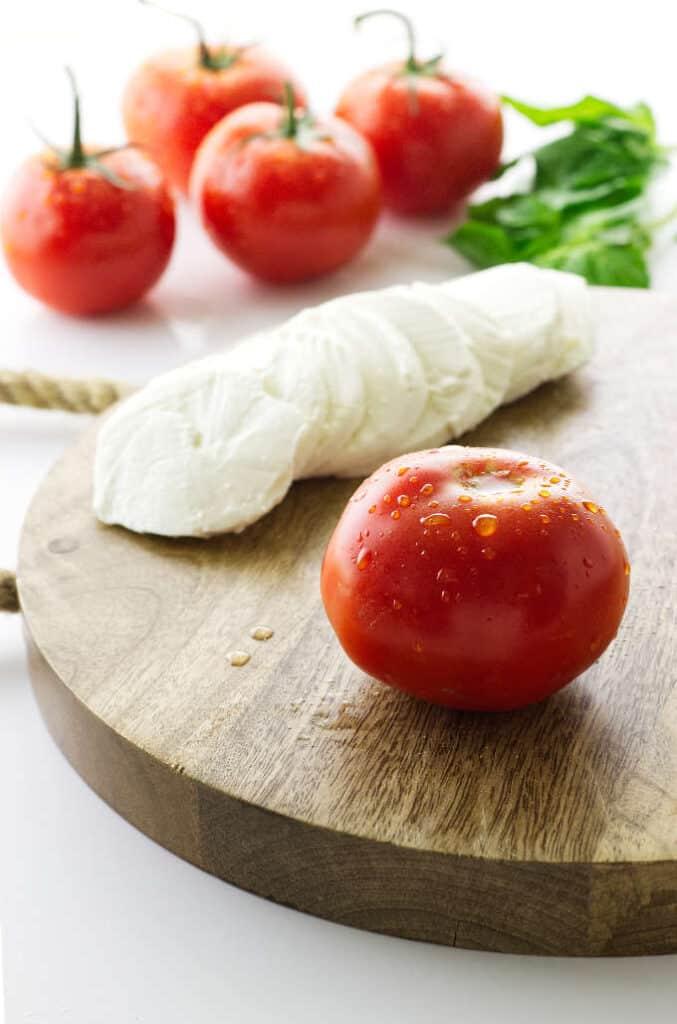close up shot of fresh tomatoes and mozzarella on a cutting board