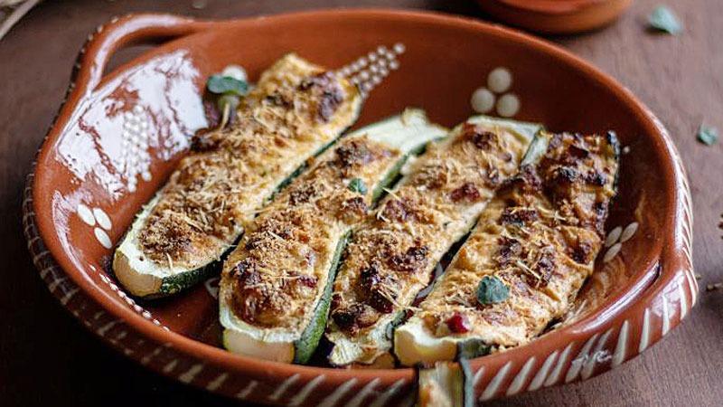 a baked dish of chorizo and zucchini with melted cheese