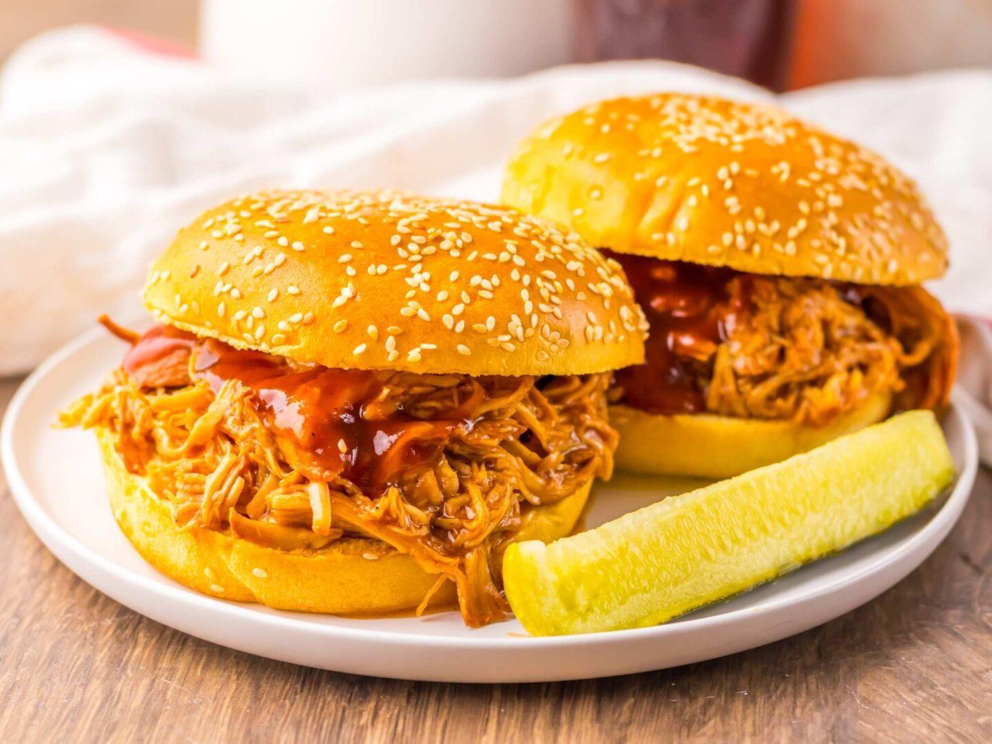 shredded cherry-cola bbq chicken being piled onto slider buns