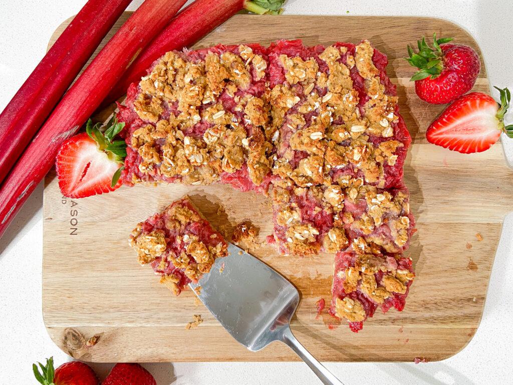 person cutting rhubarb wellness bars into squares