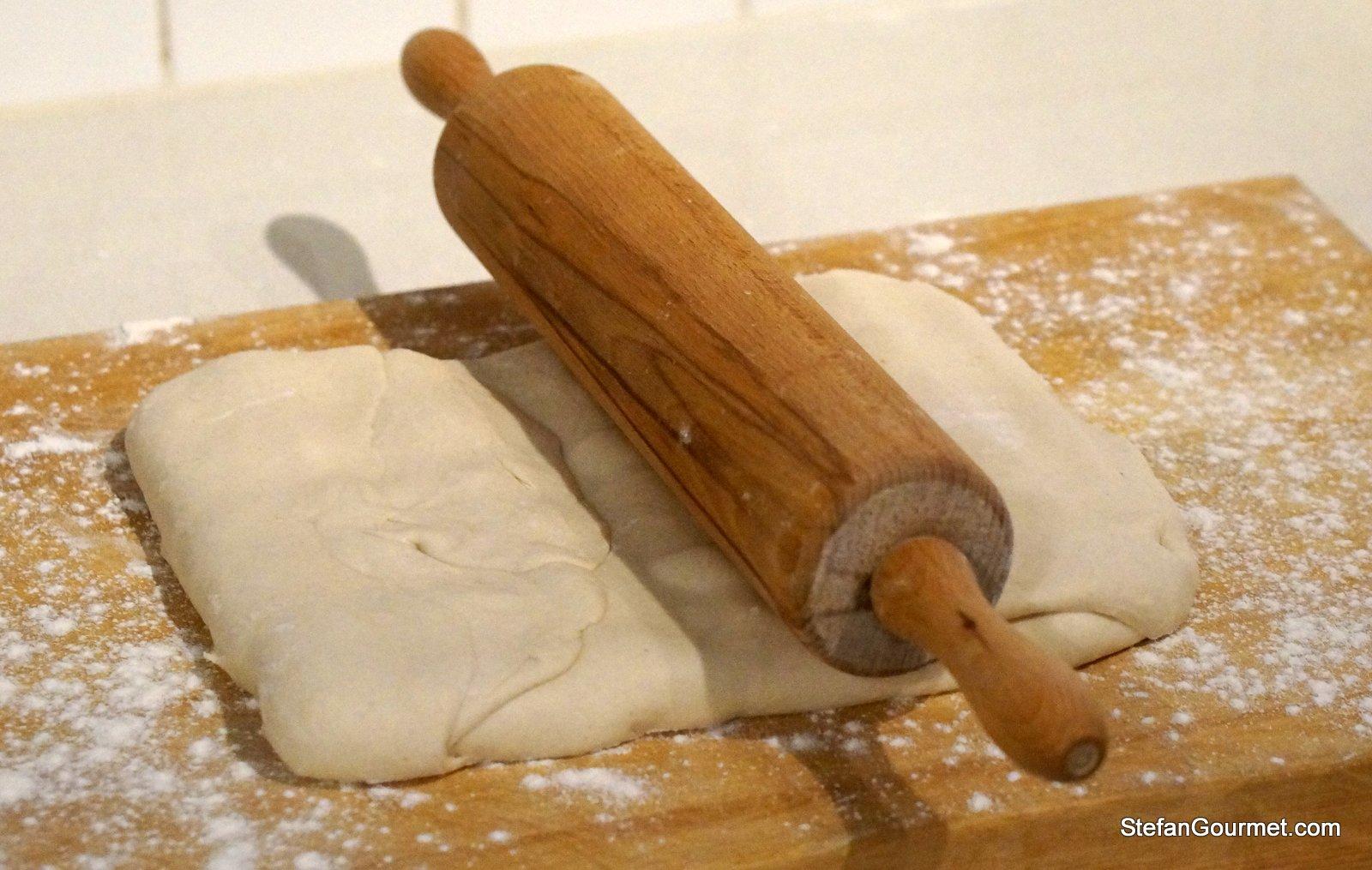 Puff pastry being rolled out on a floured surface