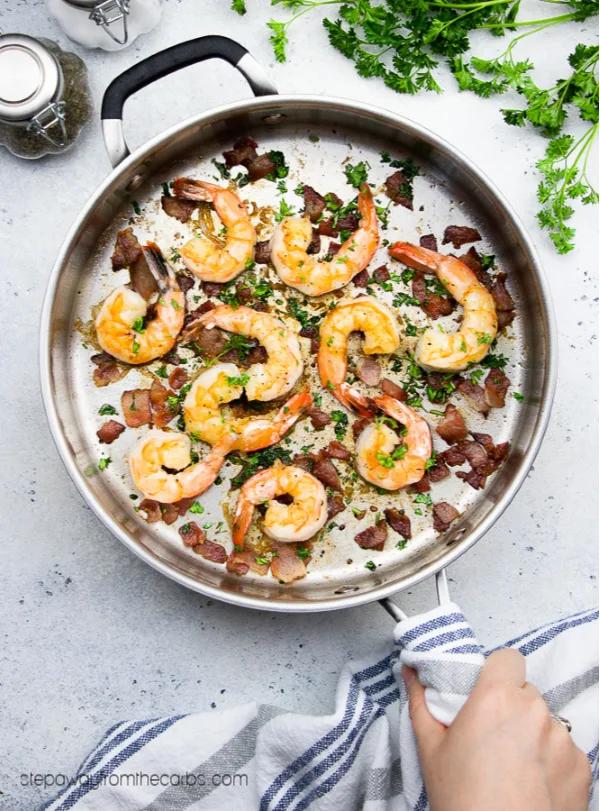 close-up of bacon garlic butter shrimp skillet, garnished with parsley