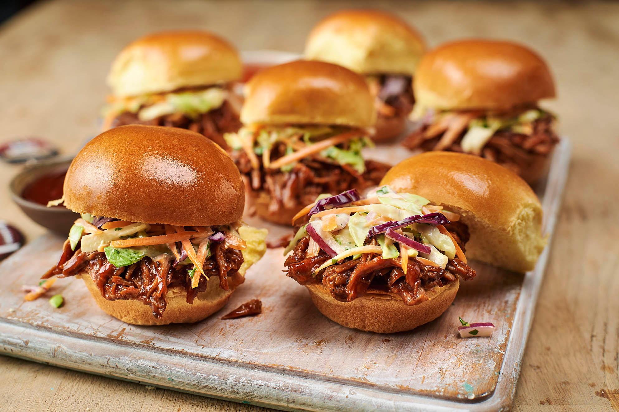 assembling pulled pork sliders with jicama slaw on mini brioche buns