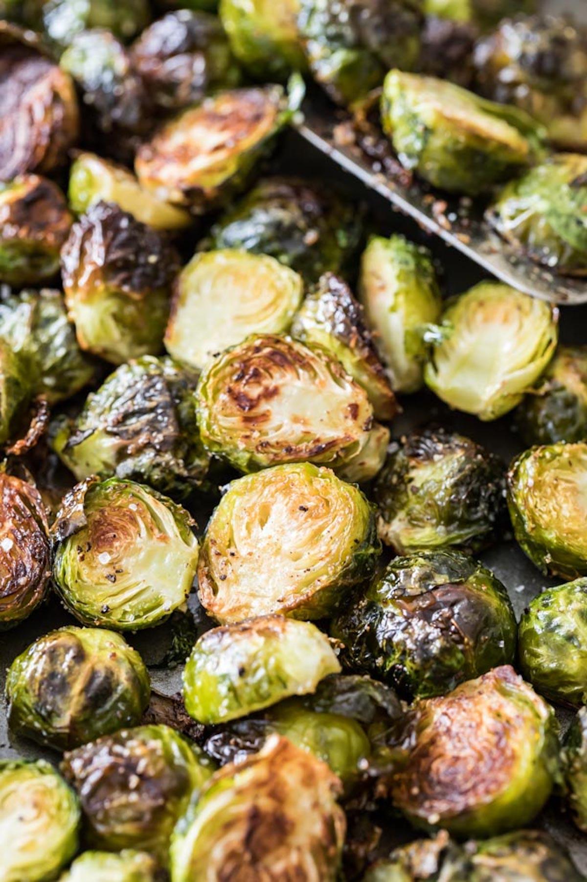 close up of roasted brussels sprouts and bell peppers on a baking sheet