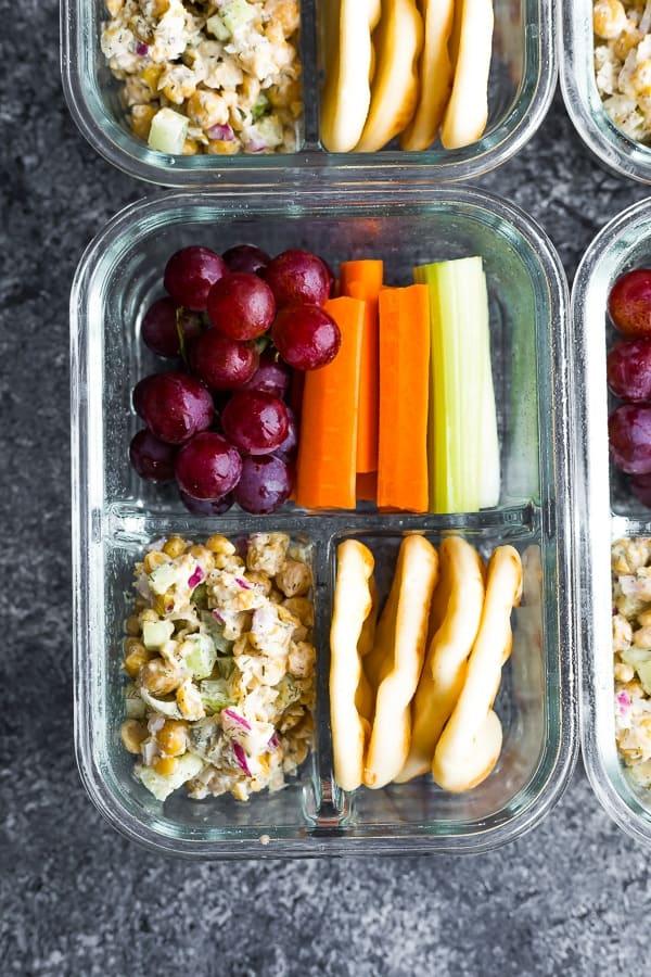 Assembling an avocado chickpea salad bento box with various compartments