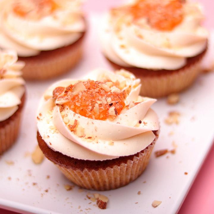 Apricot jam being spread on mini cupcakes