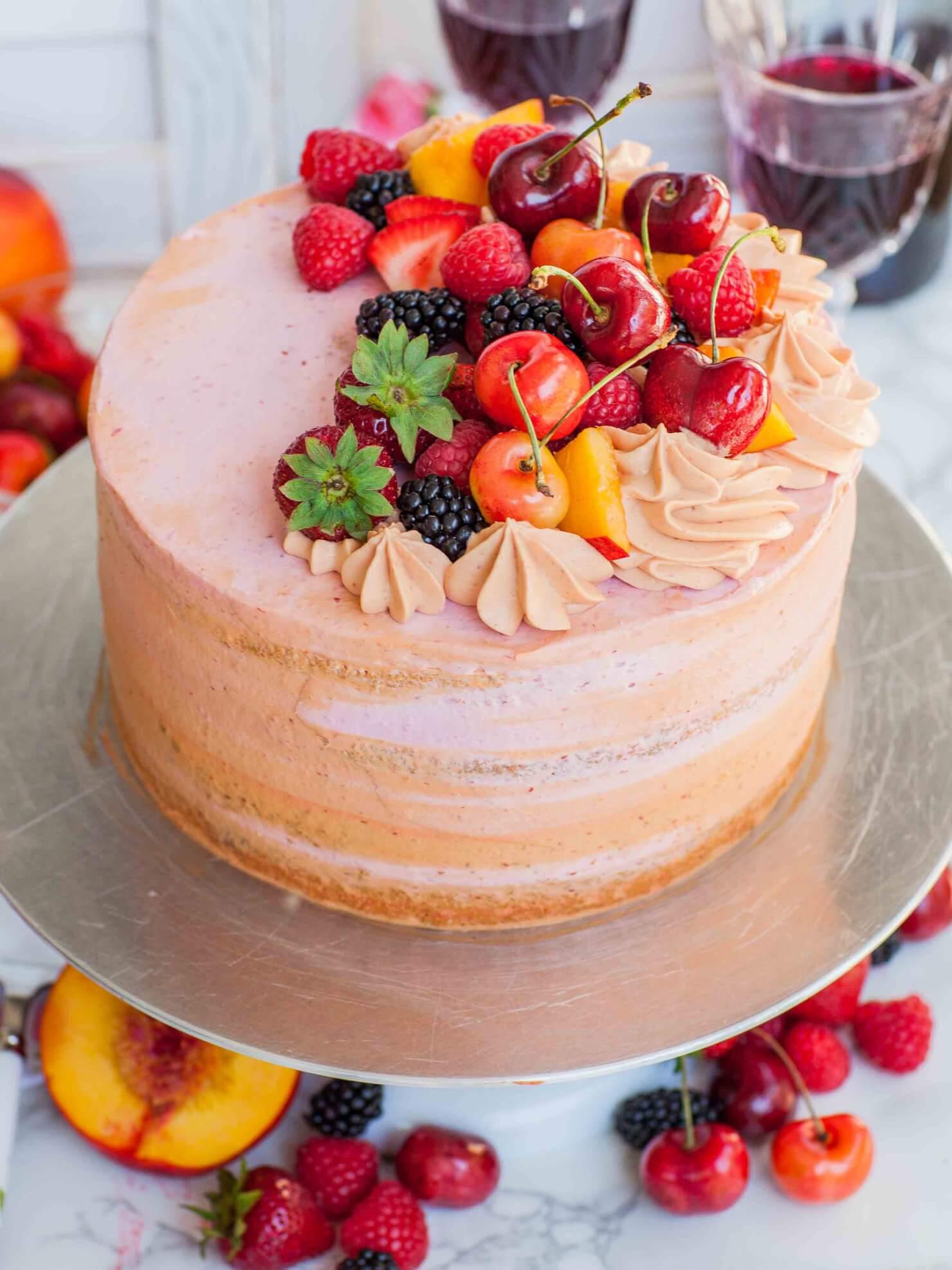 close up of a homemade strawberry sangria cake, decorated with fresh strawberries and a sangria glaze