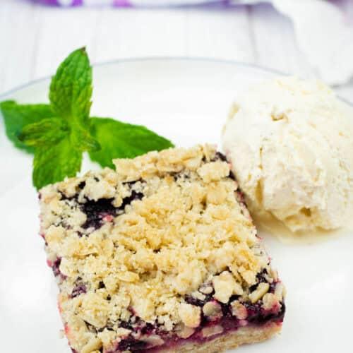 Rhubarb crumble bars served with a scoop of vanilla ice cream