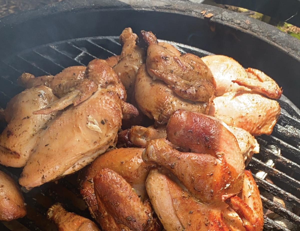 Delaware barbecue chicken being basted with sauce on a grill