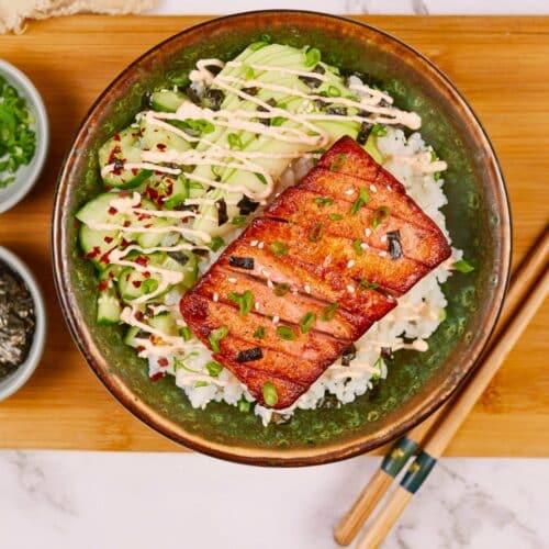 assorted marinated ingredients (tofu, salmon, broccoli) in separate bowls ready to be cooked