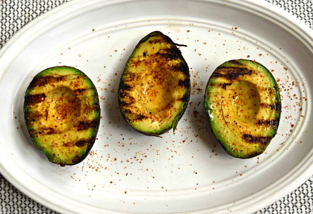 Overhead shot of finished grilled avocado halves on a plate