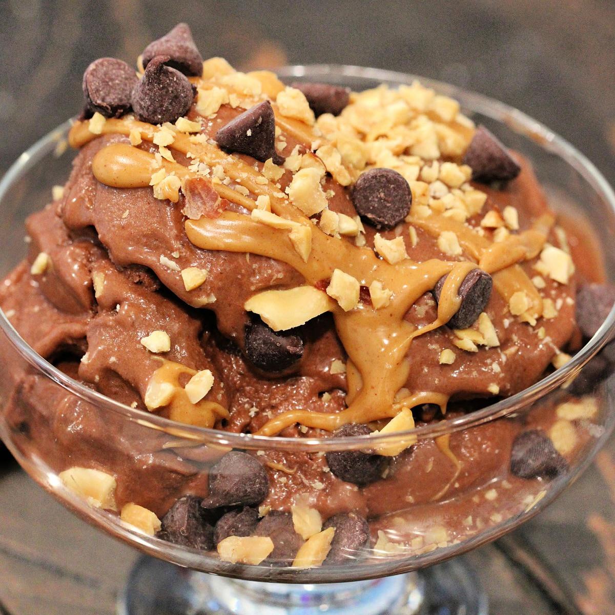 a bowl of banana ice cream with toppings like chocolate chips and nuts