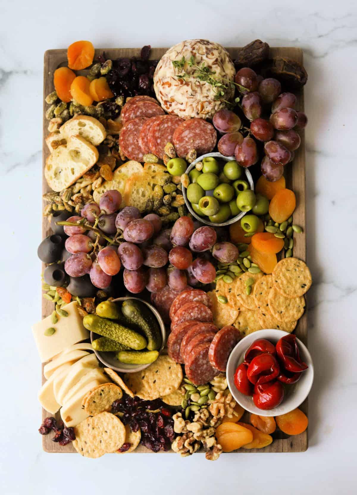 overhead shot of a beautifully arranged dried mango charcuterie board with various cheeses, nuts, fruits, and crackers