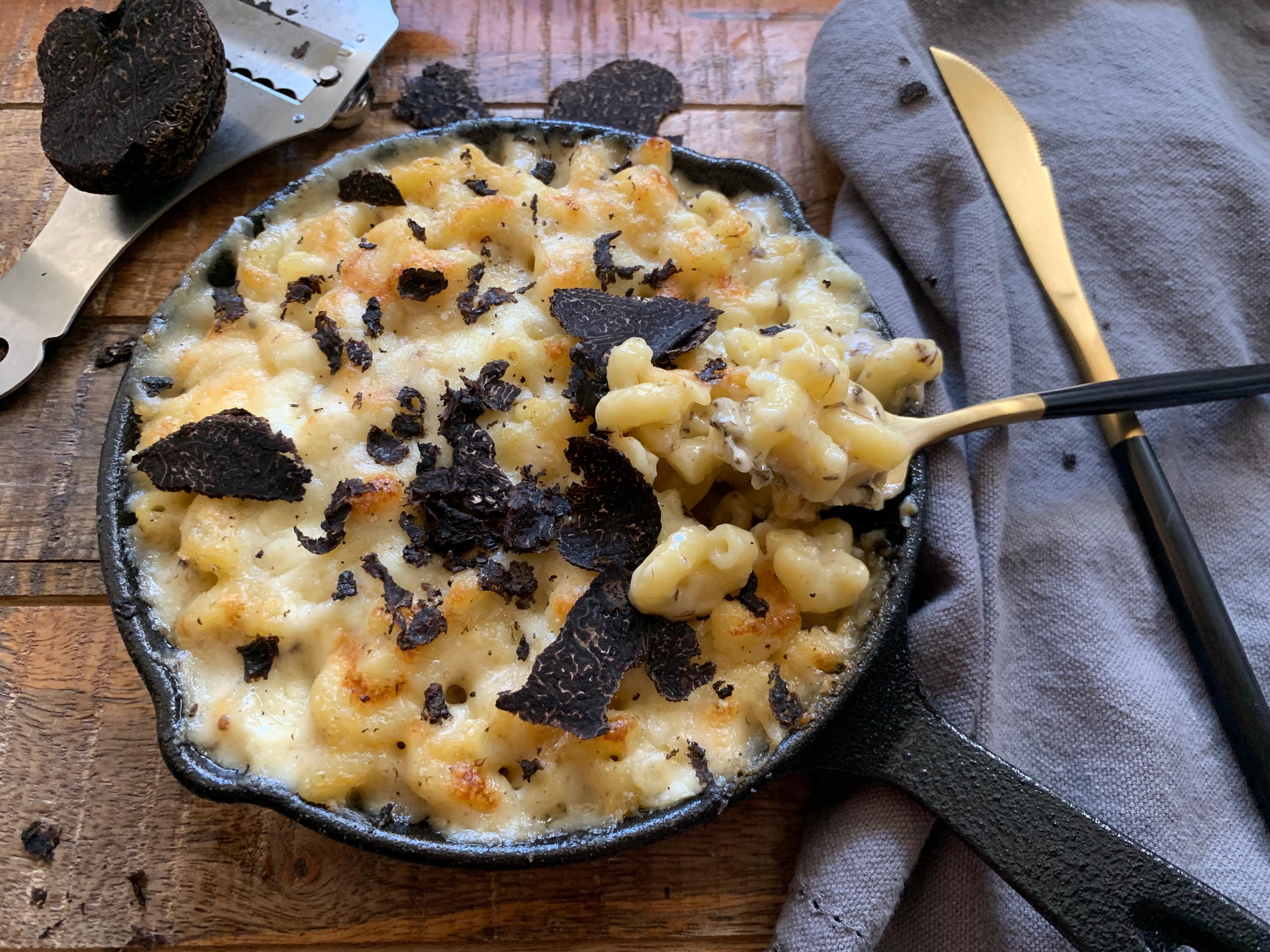 chef sprinkling black truffle salt on mac and cheese
