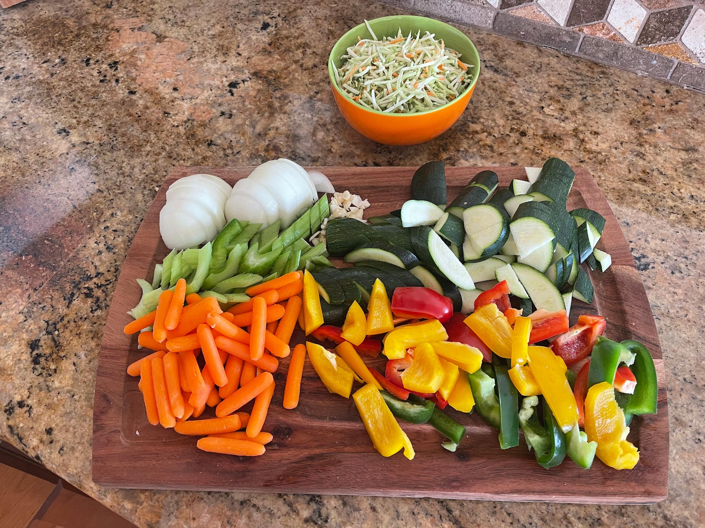 Ingredients being prepped for stir fry on a cutting board.