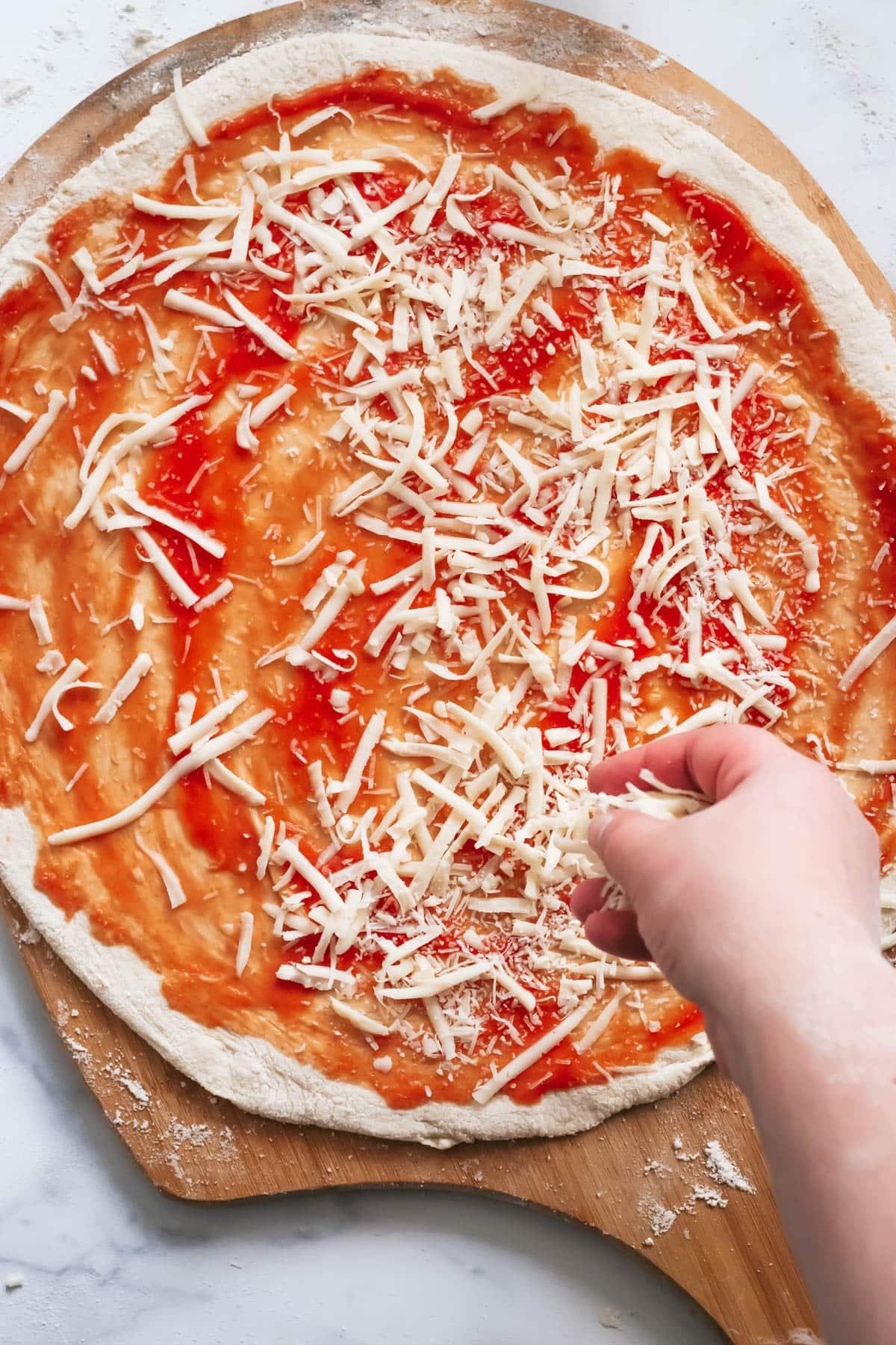 overhead shot of pizza dough being stretched on a wooden surface