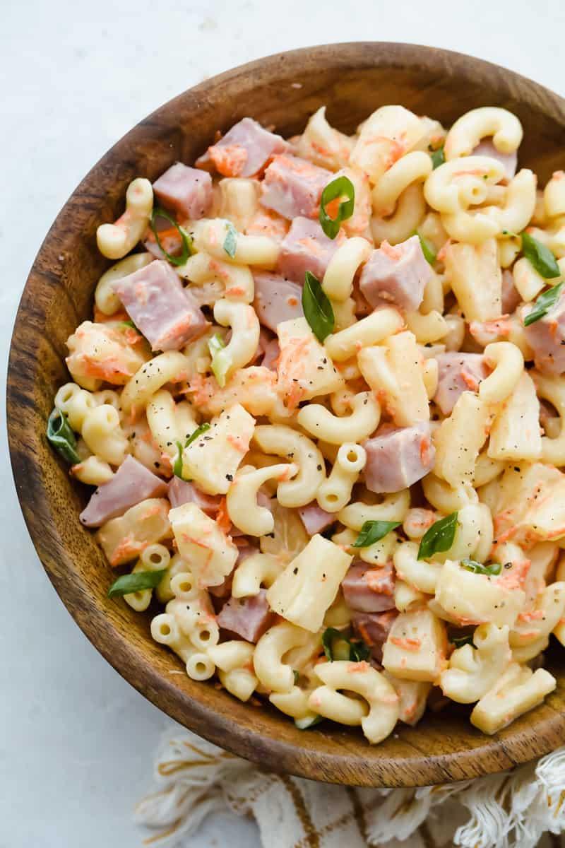 Close-up shot of creamy macaroni salad with visible ham and pineapple pieces