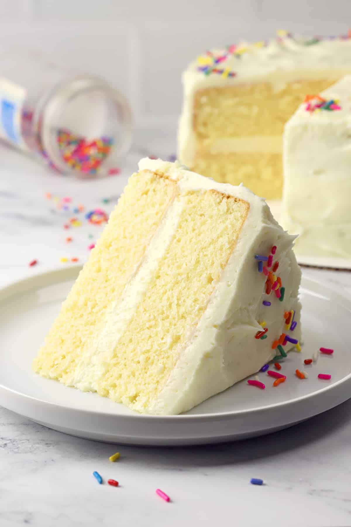 vanilla birthday cake being sliced