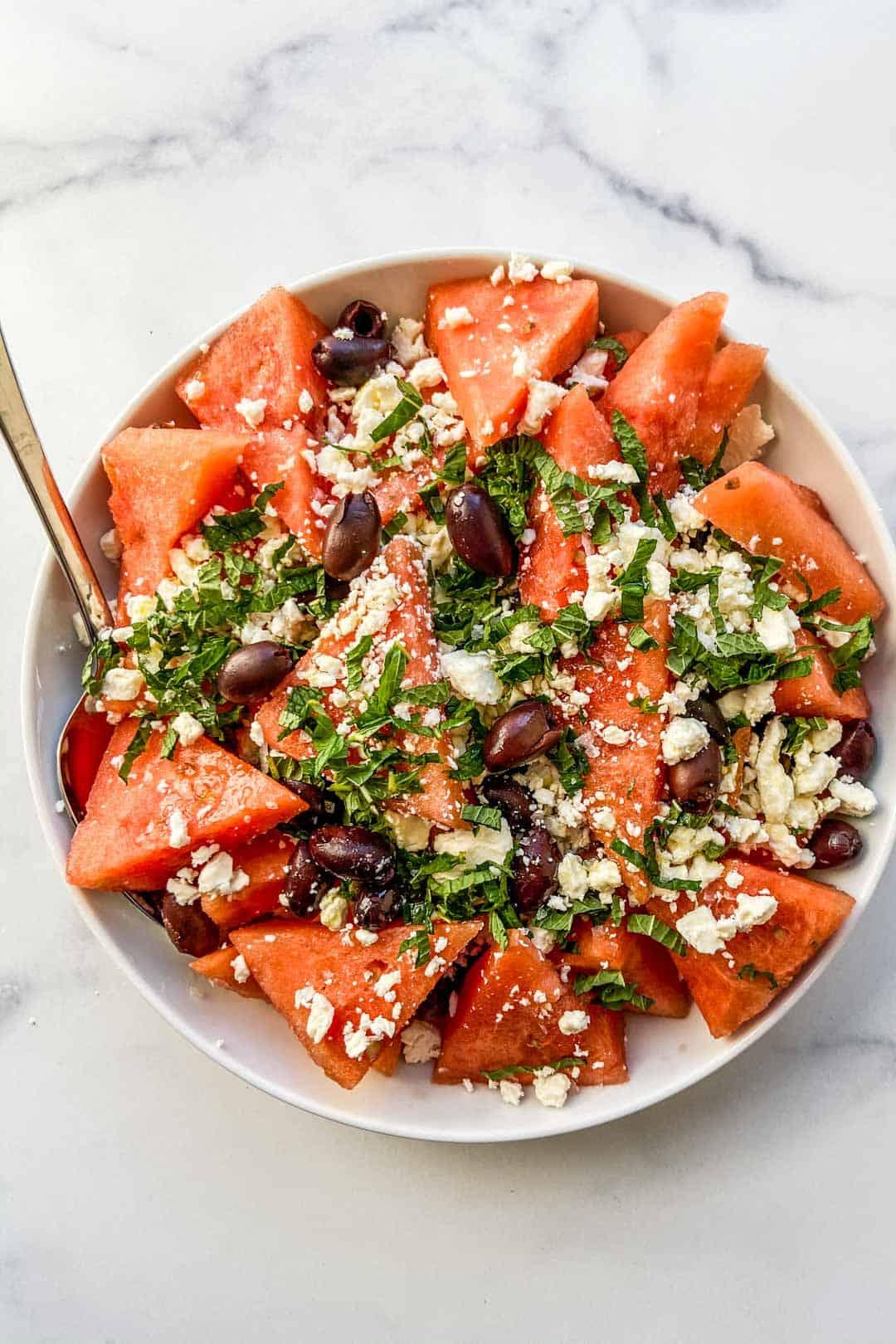 watermelon salad with kalamata olives and oregano, served outdoors