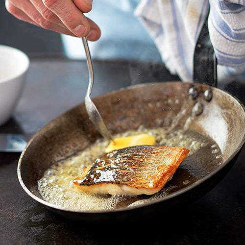 Close-up of seabass with grapes and oregano