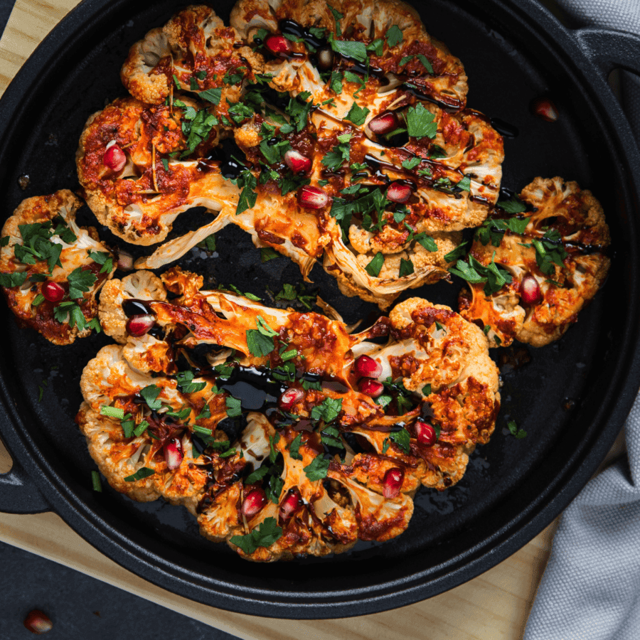 cauliflower steaks plated with balsamic fig jam, garnished with fresh herbs