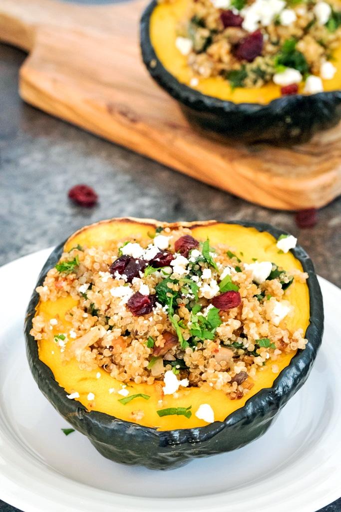 Overhead shot of acorn squash halves being stuffed with chicken quinoa mixture