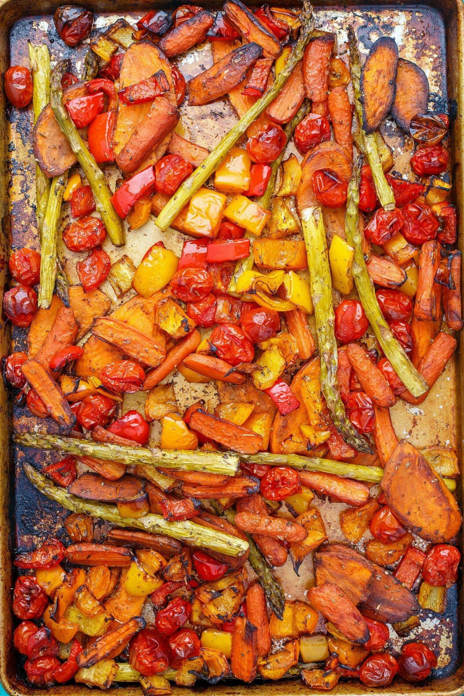 Overhead shot of roasted vegetables (bell peppers, onions, sweet potatoes, carrots) on a baking sheet