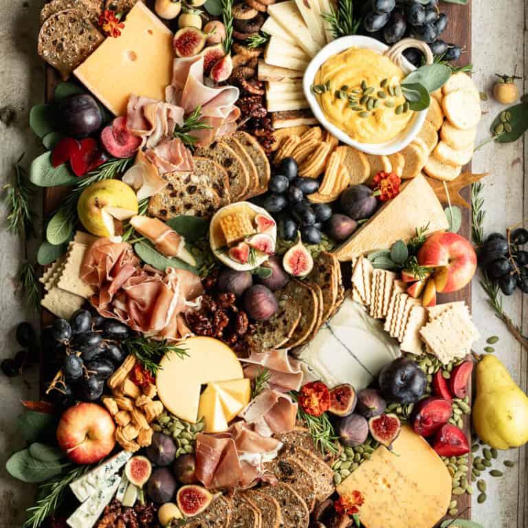 Overhead shot of a completed cheese flight with various cheeses, fruits, and nuts