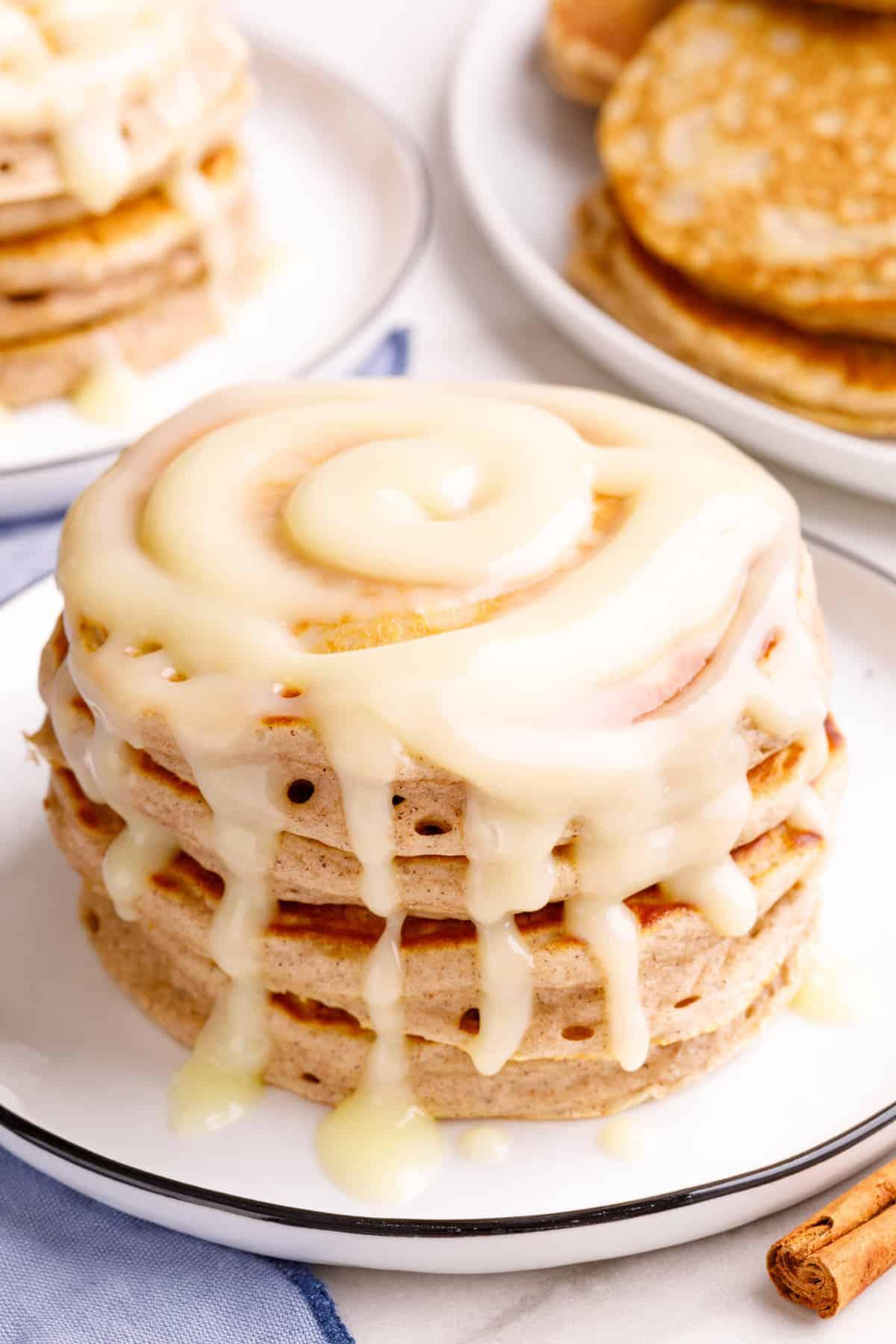 close-up of a stack of sugar cookie gluten-free pancakes being drizzled with glaze