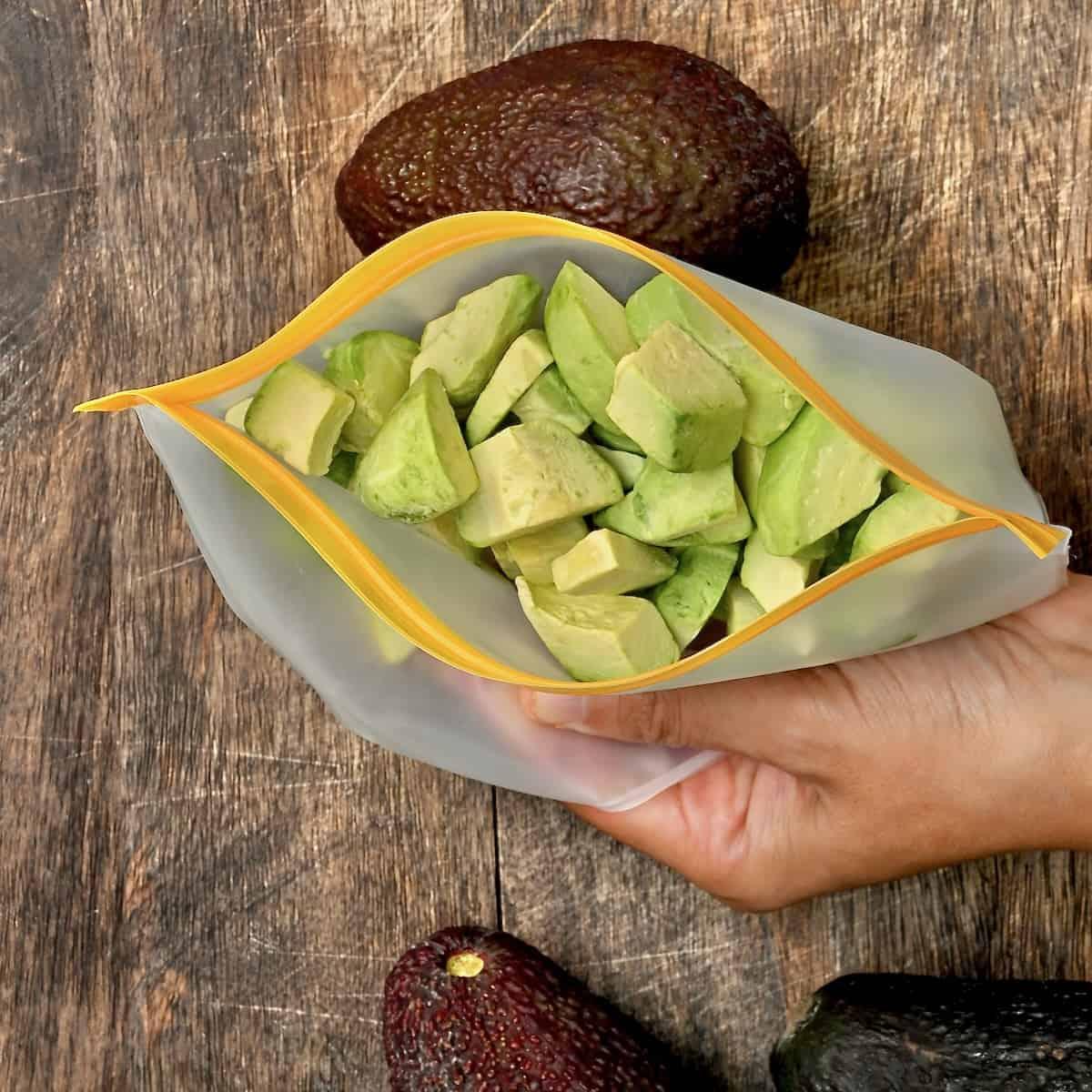 diced avocado being placed into freezer bags