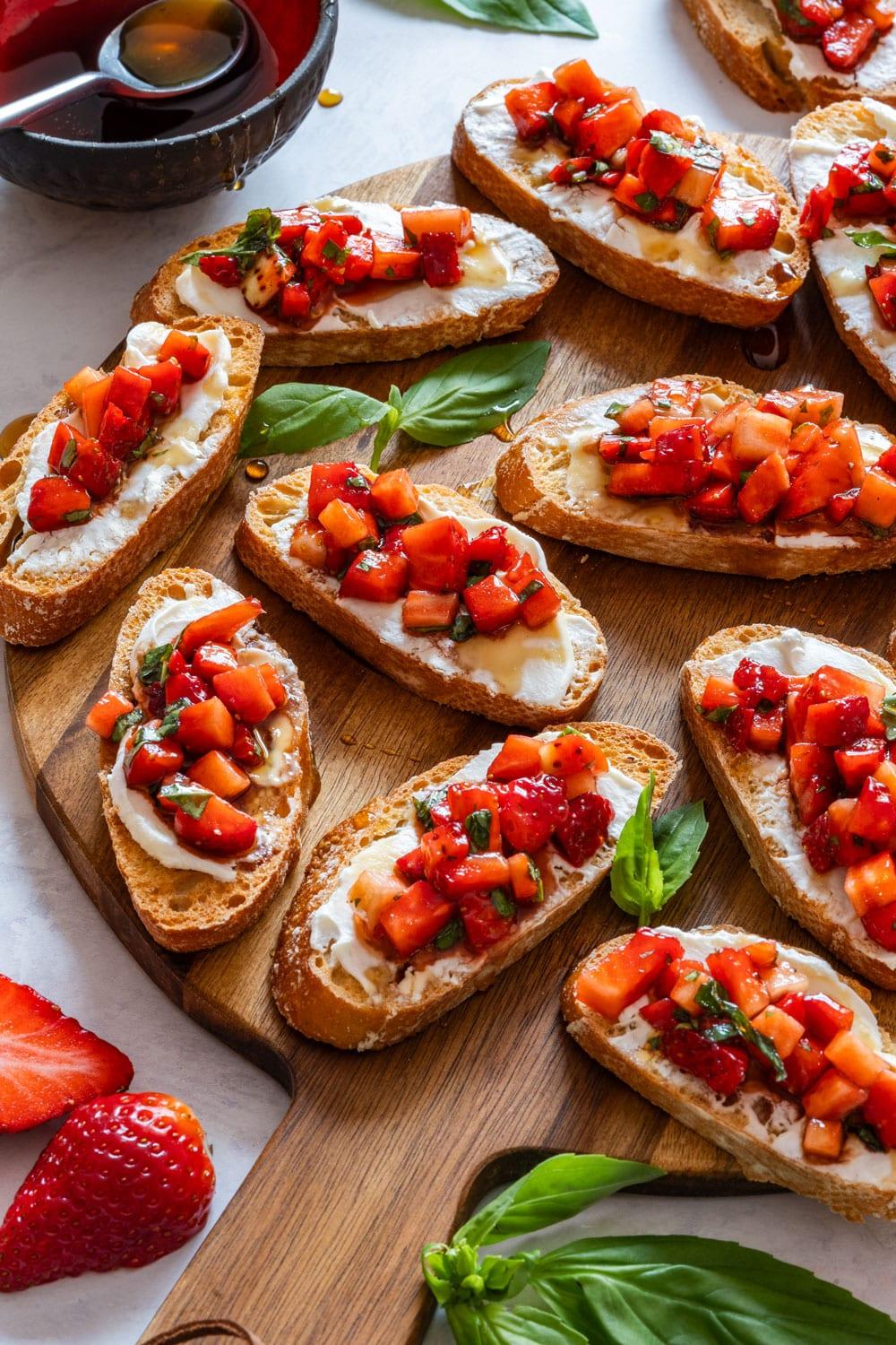 ingredients for strawberry basil bruschetta laid out on a wooden table