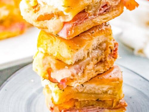 ingredients for pineapple bbq ham sliders laid out on a wooden surface, including ham, pineapple, swiss cheese, bbq sauce, and slider buns