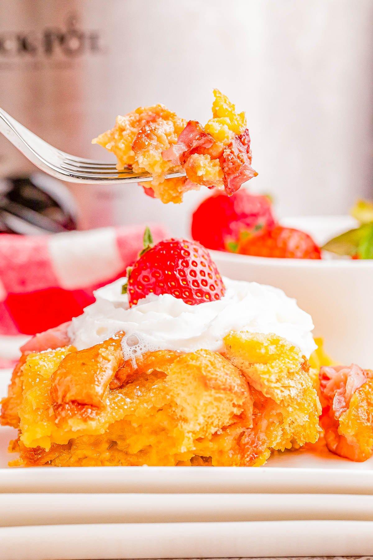 slices of strawberry shortcake bread pudding served on dessert plates with whipped cream