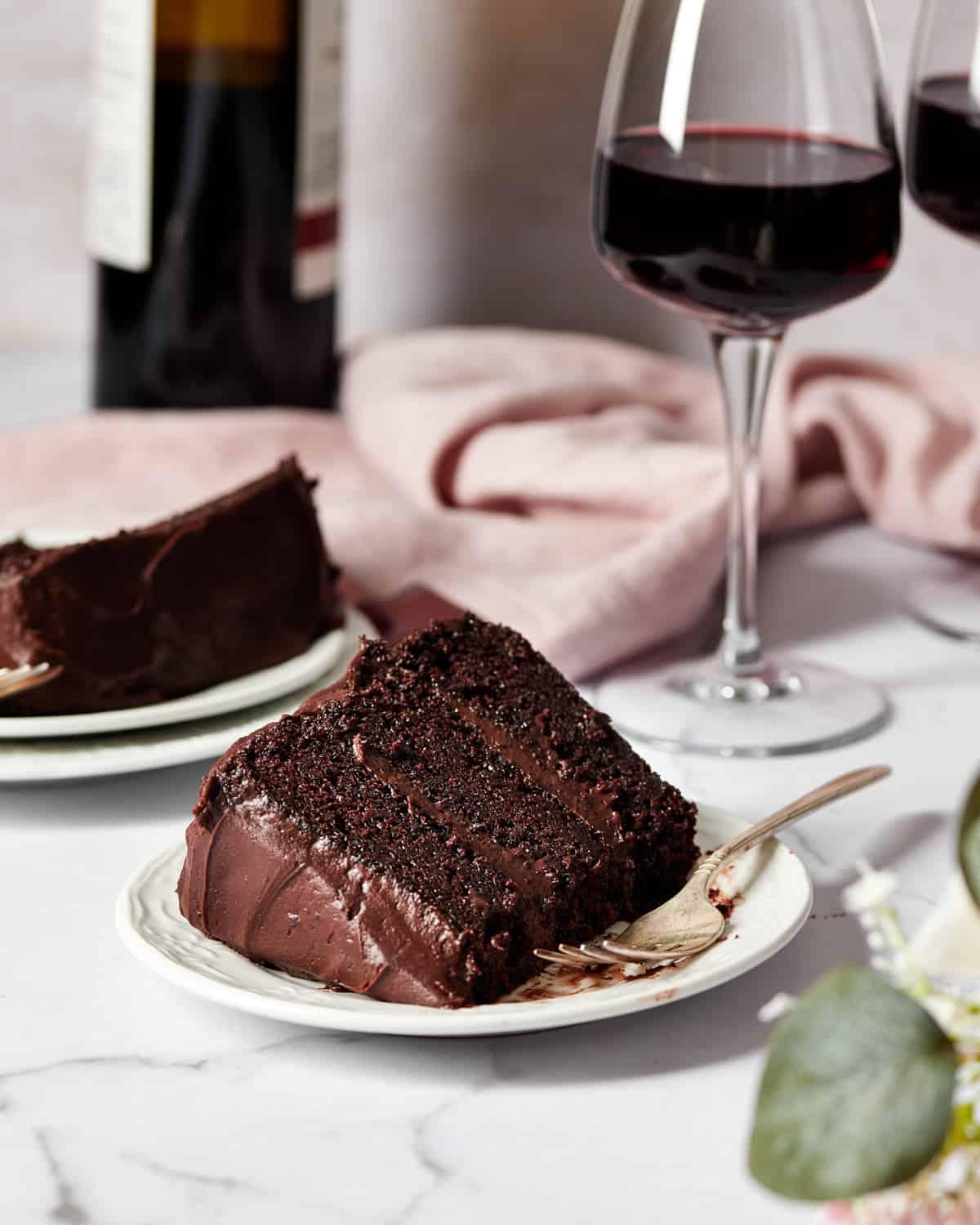 slice of red wine chocolate velvet cake with a glass of red wine